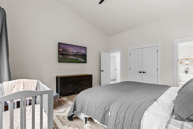 bedroom featuring ceiling fan, a closet, high vaulted ceiling, and light wood-type flooring