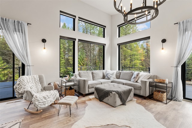 interior space featuring light hardwood / wood-style flooring, a chandelier, and a high ceiling