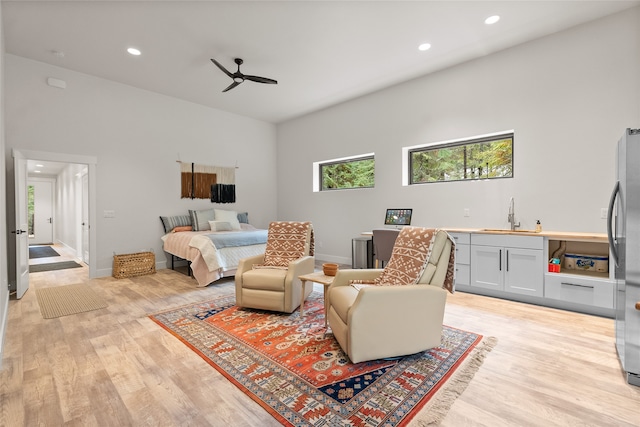 living room with ceiling fan, light hardwood / wood-style flooring, and sink