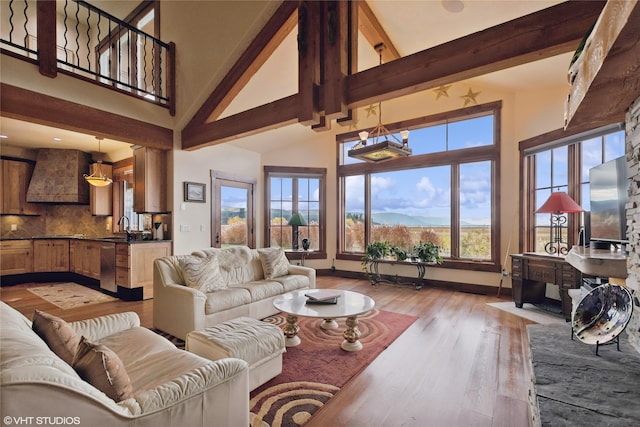 living room with a wealth of natural light, beamed ceiling, high vaulted ceiling, and wood-type flooring