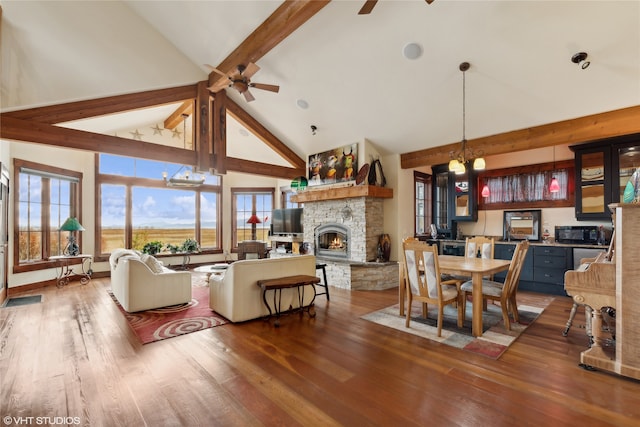 living room with hardwood / wood-style floors, a healthy amount of sunlight, and high vaulted ceiling