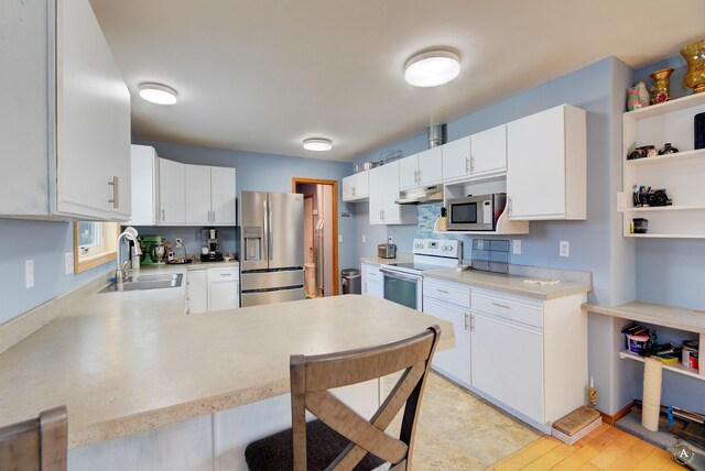 kitchen featuring stainless steel dishwasher, plenty of natural light, white cabinets, and sink