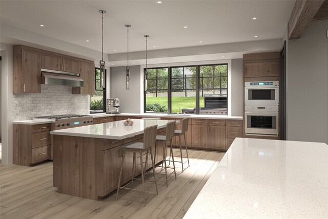 kitchen with light wood-type flooring, backsplash, a breakfast bar, white double oven, and a kitchen island