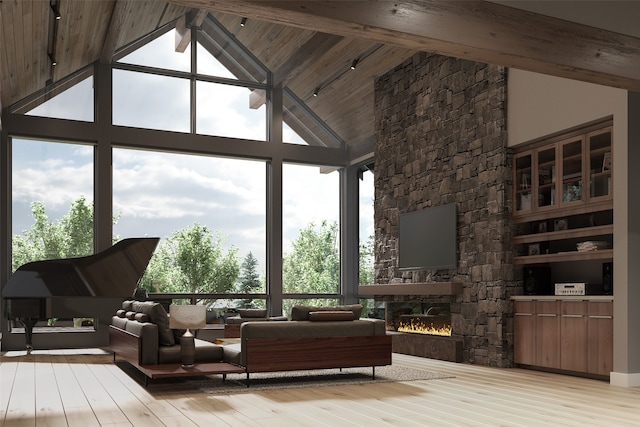 sunroom / solarium with a fireplace, lofted ceiling with beams, and plenty of natural light