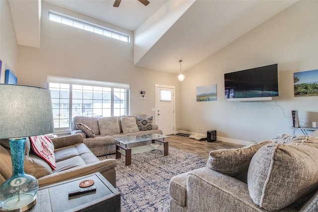 living room with hardwood / wood-style flooring, ceiling fan, and high vaulted ceiling