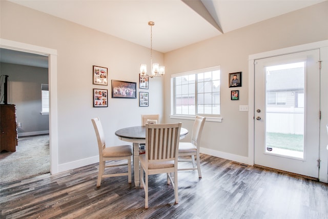 dining space featuring dark hardwood / wood-style flooring, a healthy amount of sunlight, and an inviting chandelier