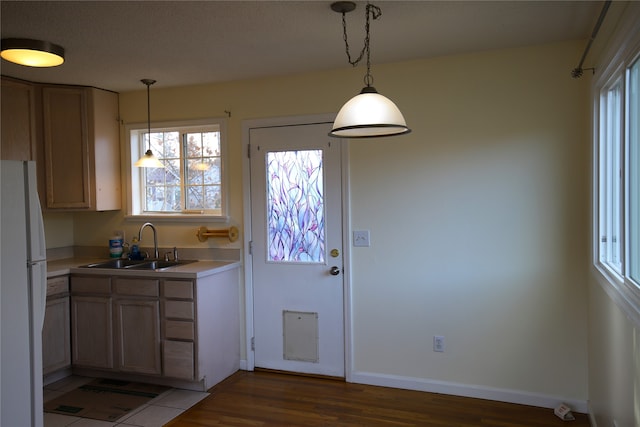 kitchen featuring pendant lighting, sink, dark hardwood / wood-style floors, light brown cabinetry, and white fridge