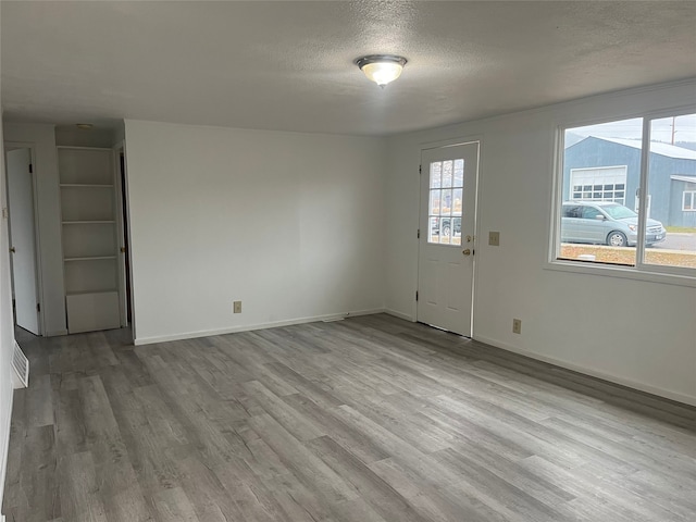 interior space featuring light hardwood / wood-style floors and a textured ceiling