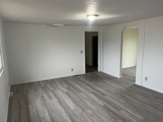 spare room featuring a textured ceiling and hardwood / wood-style flooring