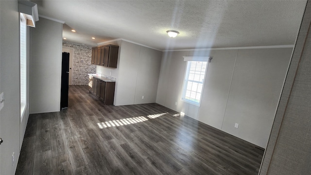 unfurnished living room featuring a textured ceiling, crown molding, and dark wood-type flooring