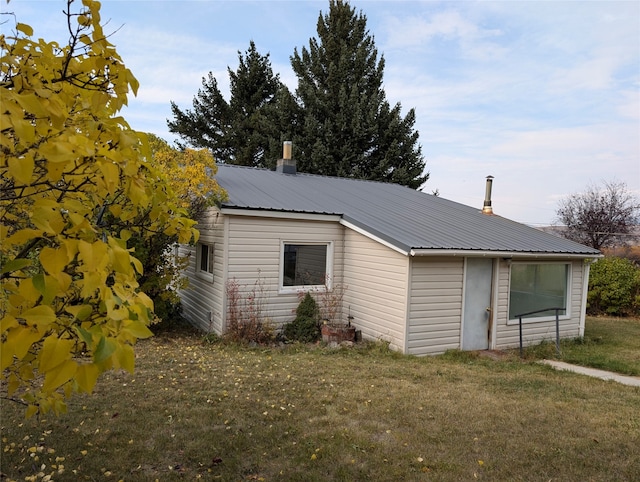 view of side of home with a yard