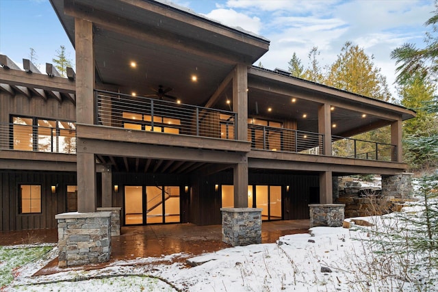 92 Woodlandstar Cir, Whitefish, MT 59937 - snow covered rear of property with board and batten siding, a patio area, a balcony, and a ceiling fan
