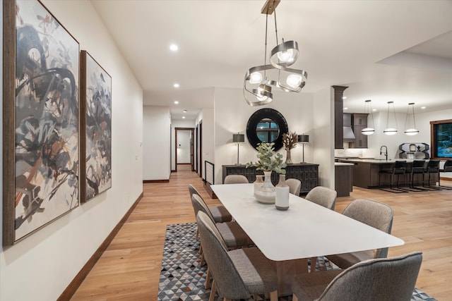 dining space with light wood-type flooring and sink