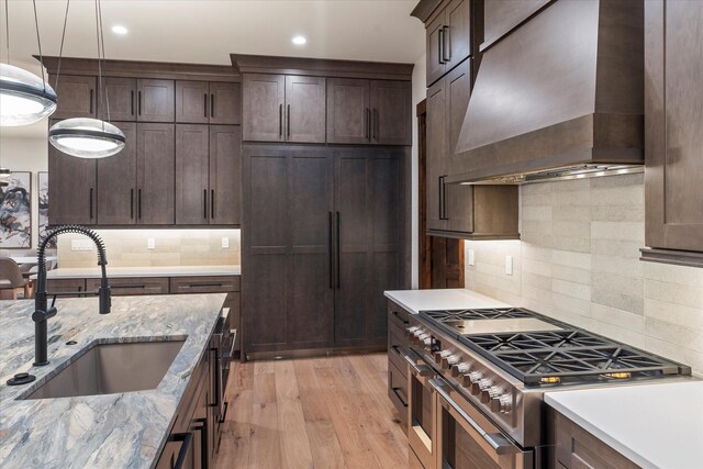 92 Woodlandstar Cir, Whitefish, MT 59937 - kitchen featuring backsplash, high end stainless steel range oven, a sink, light wood-type flooring, and custom range hood
