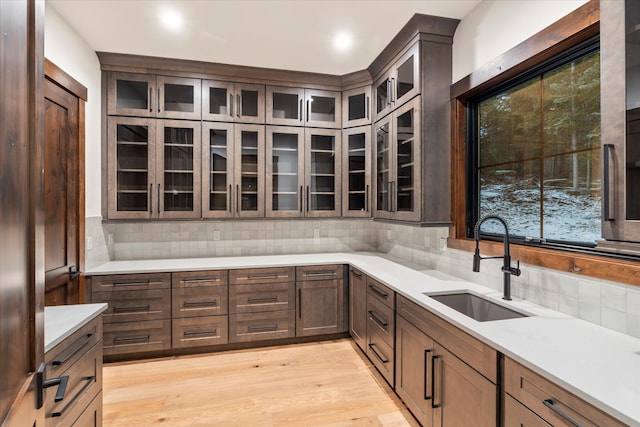 kitchen with decorative backsplash, light hardwood / wood-style flooring, and sink