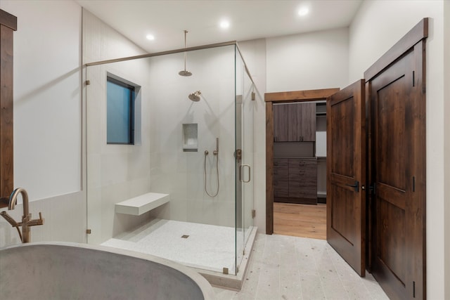 bathroom featuring a shower with shower door and hardwood / wood-style flooring