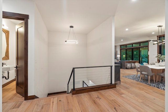 hallway with a chandelier and light wood-type flooring