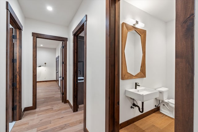 corridor with sink and light hardwood / wood-style flooring