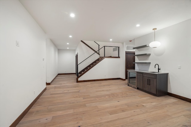 interior space with light hardwood / wood-style floors, beverage cooler, and sink