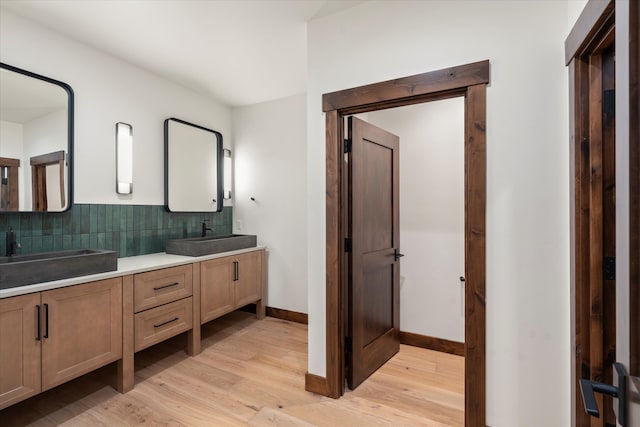 bathroom featuring vanity, wood-type flooring, and backsplash