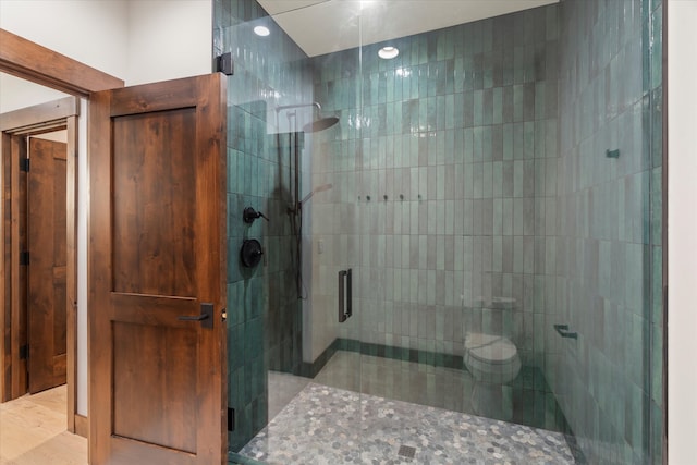 bathroom featuring an enclosed shower and toilet