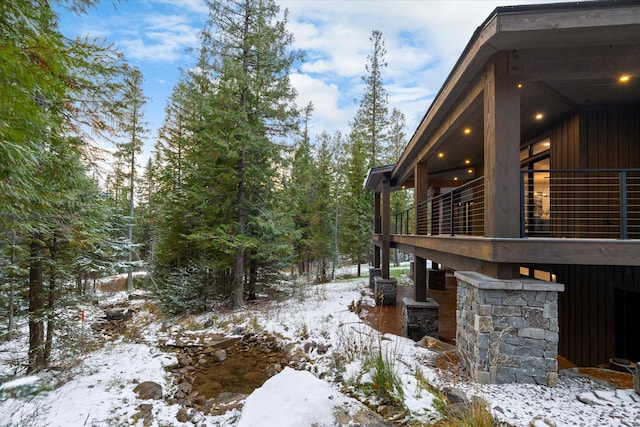 snowy yard featuring a balcony