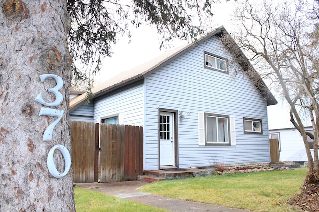 rear view of property featuring a lawn