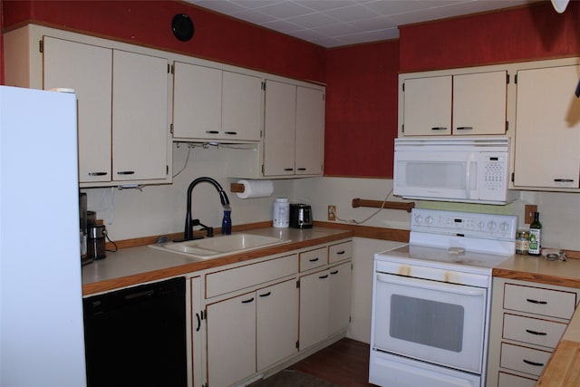 kitchen with white cabinets, white appliances, dark hardwood / wood-style floors, and sink