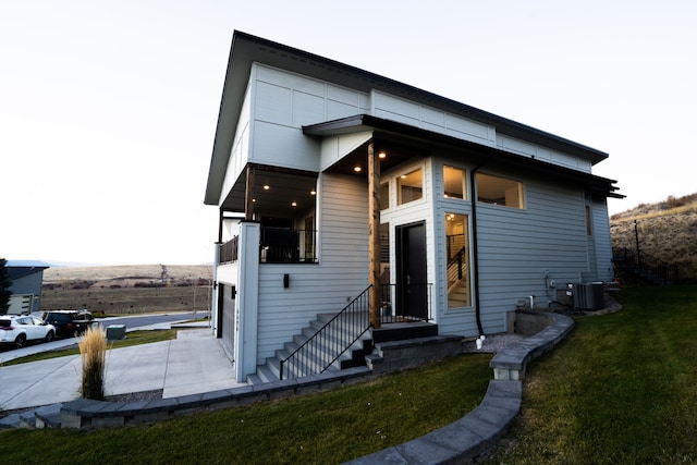 view of front of property with a front yard and central AC