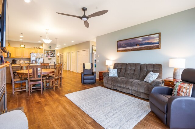 living room with dark hardwood / wood-style floors and ceiling fan