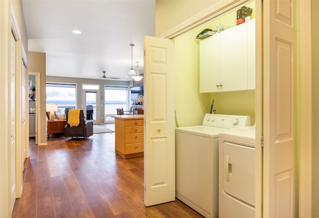 washroom with cabinets, ceiling fan, dark wood-type flooring, and washing machine and clothes dryer