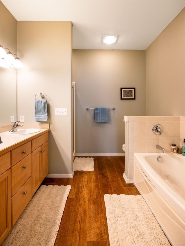 100 Rocky Point Rd Unit F5, Polson, MT 59860 - full bath with vanity, wood finished floors, a jetted tub, toilet, and baseboards