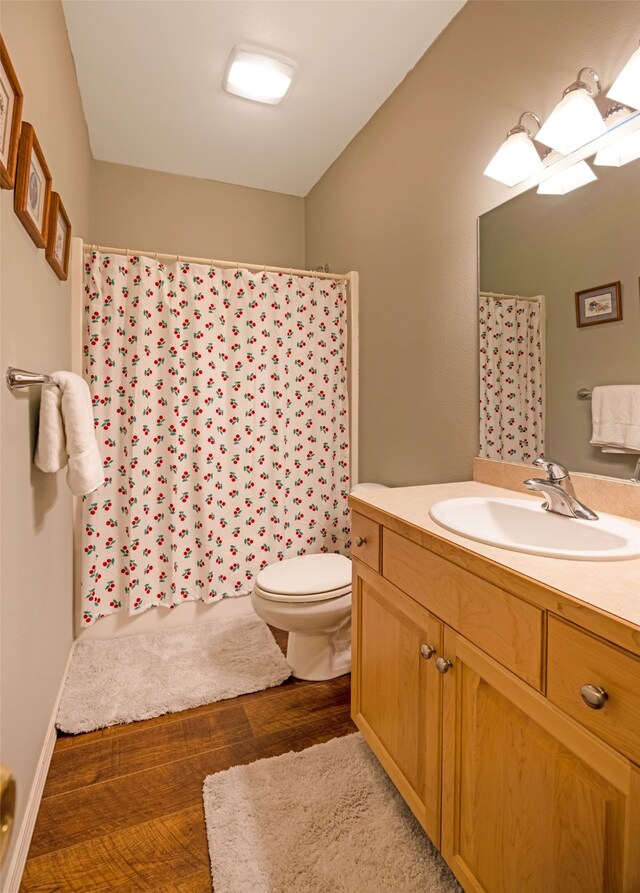 bathroom with hardwood / wood-style flooring, vanity, and toilet