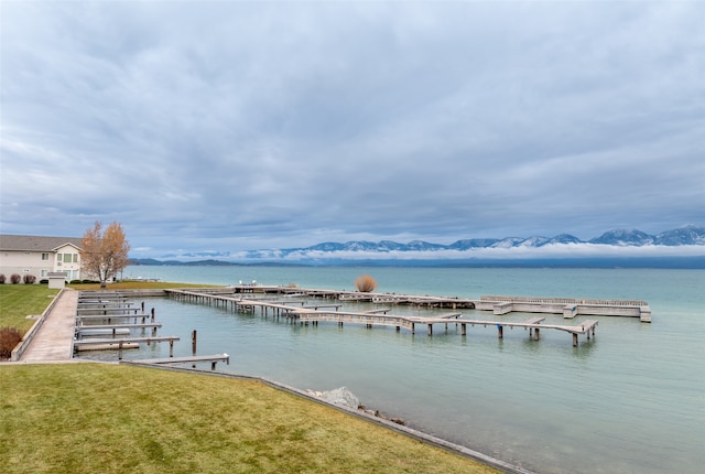 dock area with a water view and a lawn