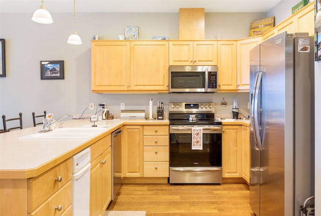 100 Rocky Point Rd Unit F5, Polson, MT 59860 - kitchen featuring appliances with stainless steel finishes, light brown cabinetry, a peninsula, and light wood-style flooring