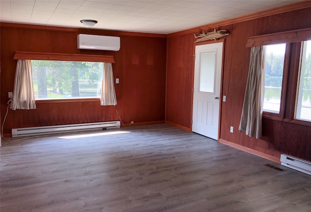 empty room featuring a baseboard radiator, a wall mounted AC, dark wood-type flooring, and wood walls