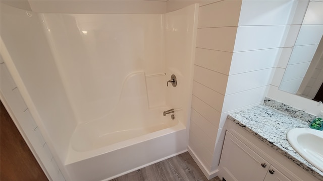 bathroom with vanity, wood-type flooring, and washtub / shower combination