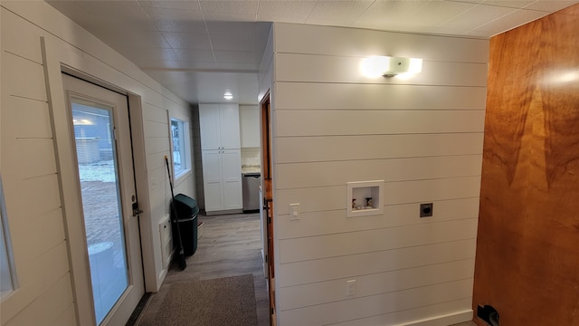 washroom featuring hookup for an electric dryer, hardwood / wood-style floors, wooden walls, and washer hookup