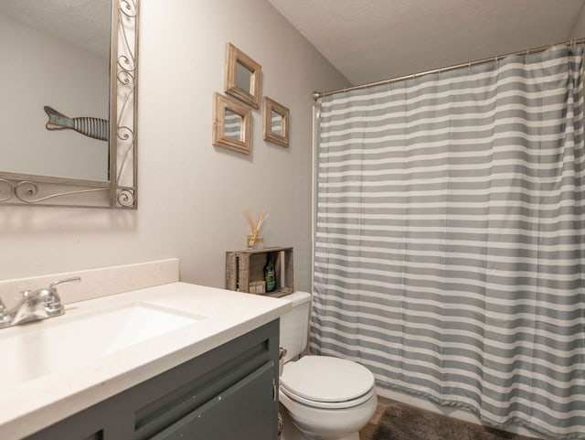 bathroom featuring vanity, toilet, and a textured ceiling