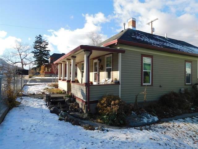 snow covered property featuring covered porch