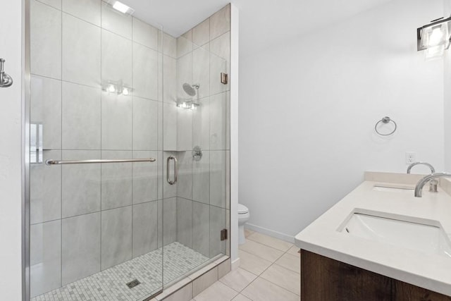 bathroom with tile patterned flooring, vanity, toilet, and a shower with shower door