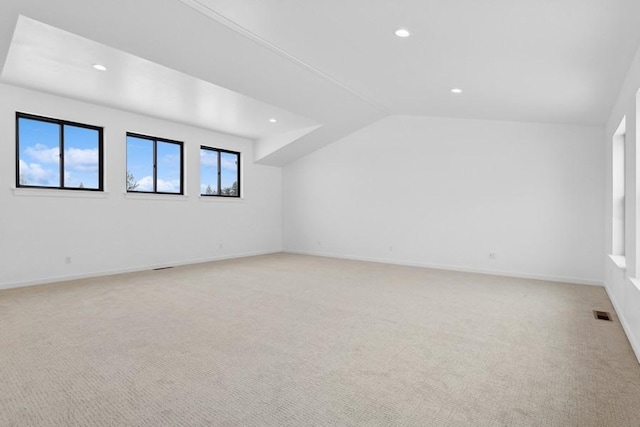 additional living space with light carpet and vaulted ceiling