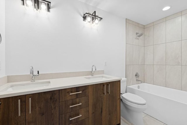 full bathroom featuring tiled shower / bath, tile patterned flooring, vanity, and toilet