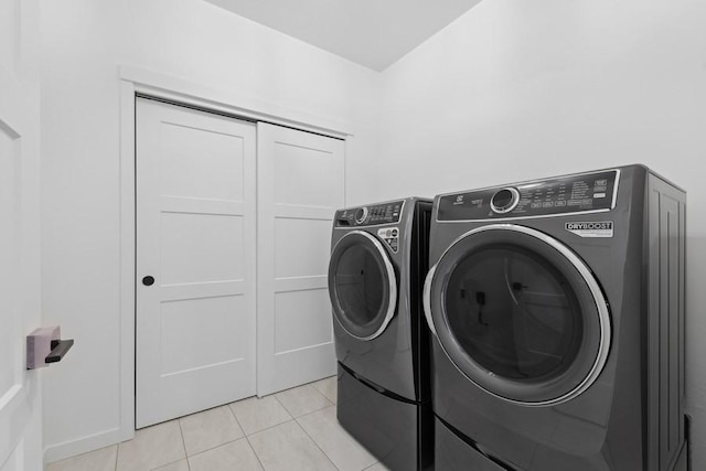 laundry room featuring light tile patterned floors and separate washer and dryer