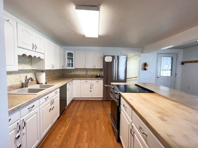 kitchen with appliances with stainless steel finishes, tasteful backsplash, sink, dark hardwood / wood-style floors, and white cabinetry