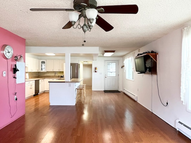 kitchen with white cabinets, a textured ceiling, dark hardwood / wood-style flooring, and a baseboard heating unit