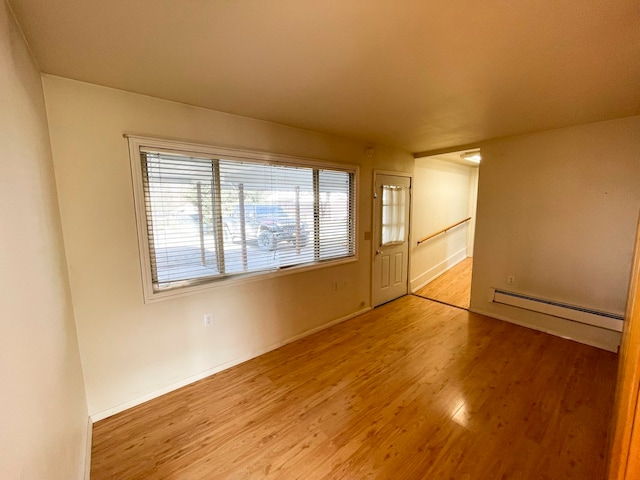 empty room featuring light hardwood / wood-style floors and a baseboard heating unit