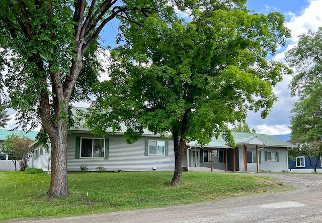 ranch-style house with covered porch and a front lawn