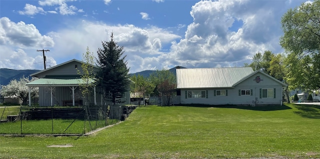 back of house with a mountain view and a yard