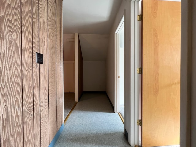 hall with light colored carpet and vaulted ceiling